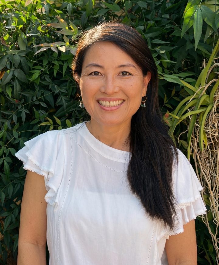 Yumi Matsubara sorrindo com vegetação natural ao fundo